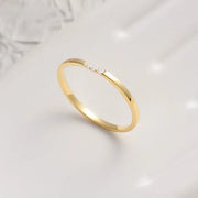 14k Gold filled tiny ring with small diamonds on a light gray background